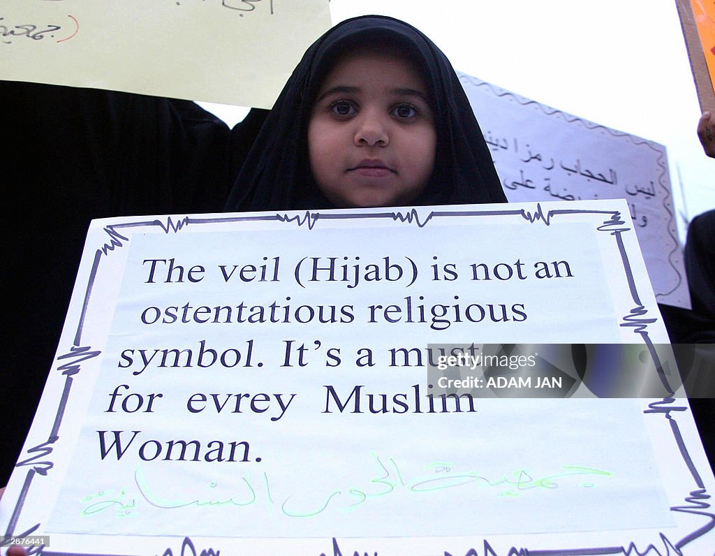 A Bahraini girl holds up a banner during