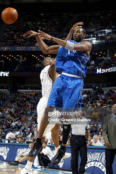 Tracy McGrady of the Orlando Magic passes around George Lynch of the New Orleans Hornets January 17, 2004 in New Orleans, Louisiana. NOTE TO USER:...