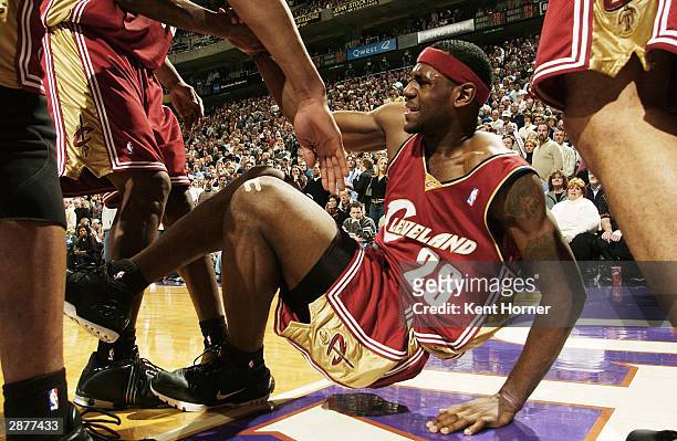 LeBron James of the Cleveland Cavaliers is assisted by teammates after getting injured against the Utah Jazz on January 17, 2004 at the Delta Center...