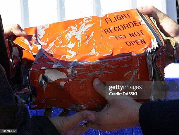 Egyptian officials hold the flight recorder from a crashed passenger plane 18 January 2004 at the Red sea resort of Sharm el-Sheikh. Search teams...