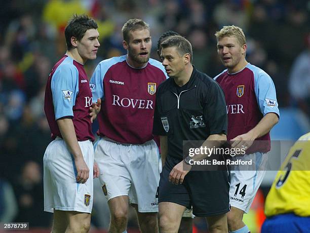 Gareth Barry, Olof Mellberg, and Marcus Allback of Aston Villa surround referee Mr M Halsey to complain about the penalty Arsenal were awarded during...