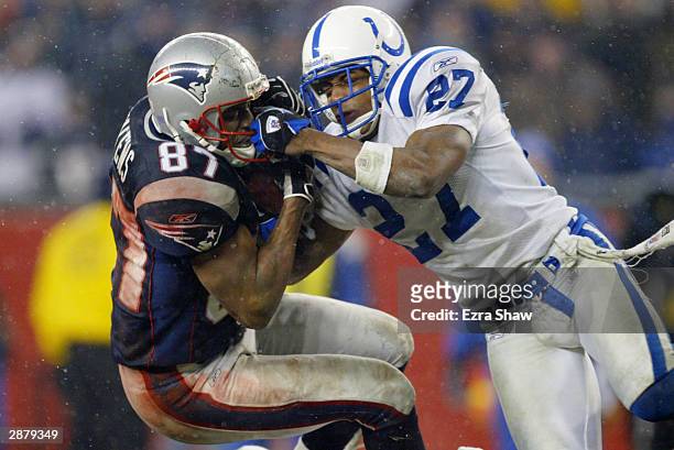 Wide receiver David Givens of the New England Patriots and cornerback David Macklin of the Indianapolis Colts fight for the ball in the AFC...