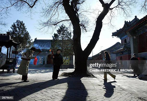 Woman prays in the serene setting of the Baiyunguan temple in Beijing, one of the oldest Taoist temples in northern China which dates back over 1,000...