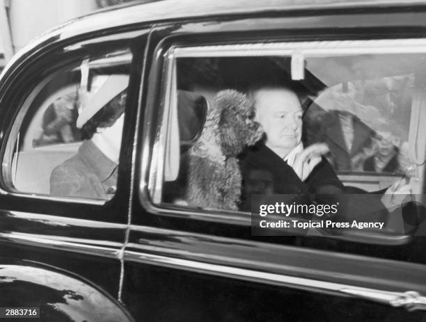 British prime minister Winston Churchill leaves Buckingham Palace after a short visit, accompanied by his poodle Rufus, 25th September 1951.