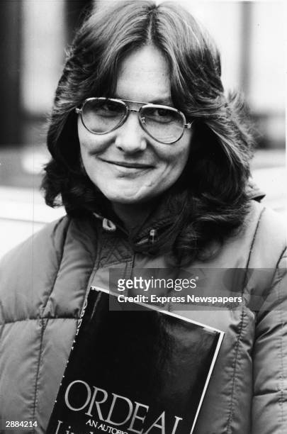 American actor and adult film star Linda Lovelace holds her book 'Ordeal' in London, England, April 4, 1981.