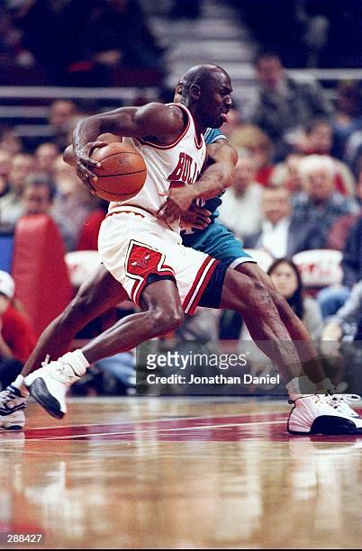 Guard Michael Jordan of the Chicago Bulls moves the ball during a game against the Charlotte Hornets at the United Center in Chicago, Illinois. The...