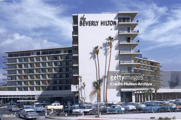 Exterior view of the Beverly Hills Hilton with cars parked in front, California. Circa 1950s.