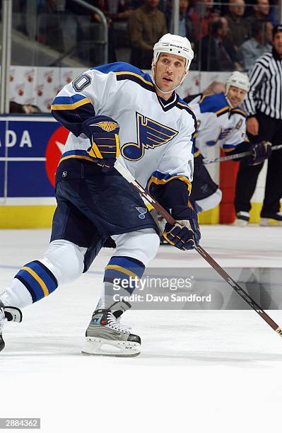 Dallas Drake of the St. Louis Blues eyes the play as he skates against the Toronto Maple Leafs at Air Canada Centre on December 9, 2003 in Toronto,...