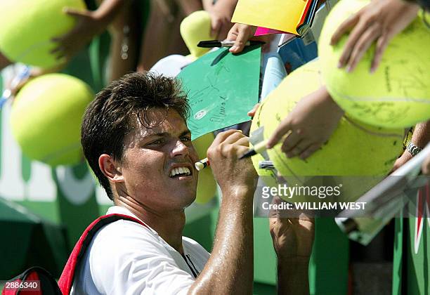 Taylor Dent of the US, the son of former Aussie tennis great Phil Dent, signs autographs for fans following his victory over Juan Ignacio Chela of...