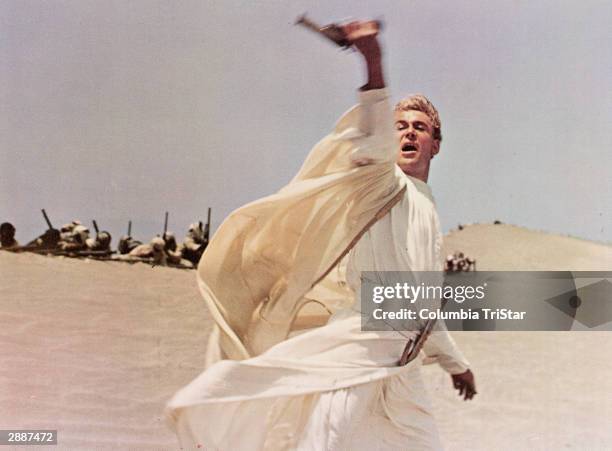 Irish-born actor Peter O'Toole waves his pistol while leading an army through the desert in a still from the film, 'Lawrence of Arabia,' directed by...