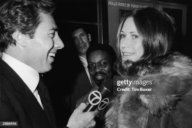 American adult film actor Marilyn Chambers is interviewed by reporter Kevin Sanders as she attends the premiere of the film, 'Resurrection of Eve,'...