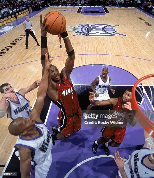 Lamar Odom of the Miami Heat goes up for a dunk over Anthony Peeler of the Sacramento Kings during the game at Arco Arena on January 13, 2004 in...