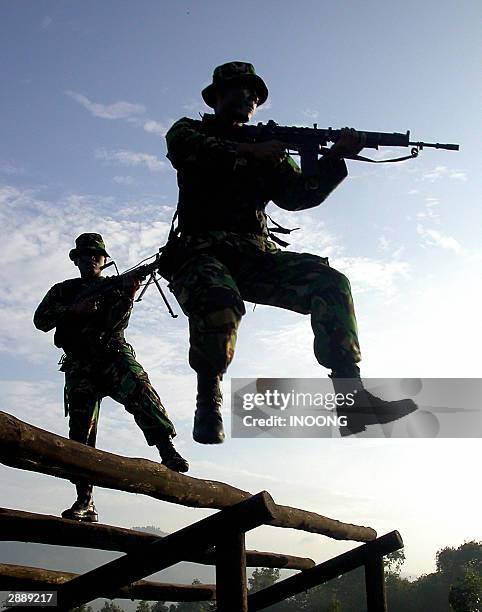 Indonesian soldiers practice shooting while jumping from a stage in Bandung, 22 January 2003. Indonesia's powerful military is leaving politics for...
