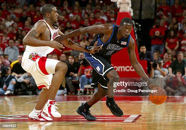 Luol Deng of the Duke Blue Devils tries to hold off Travis Garrison of the Maryland Terrapins as he brings the ball upcourt as the Blue Devils...