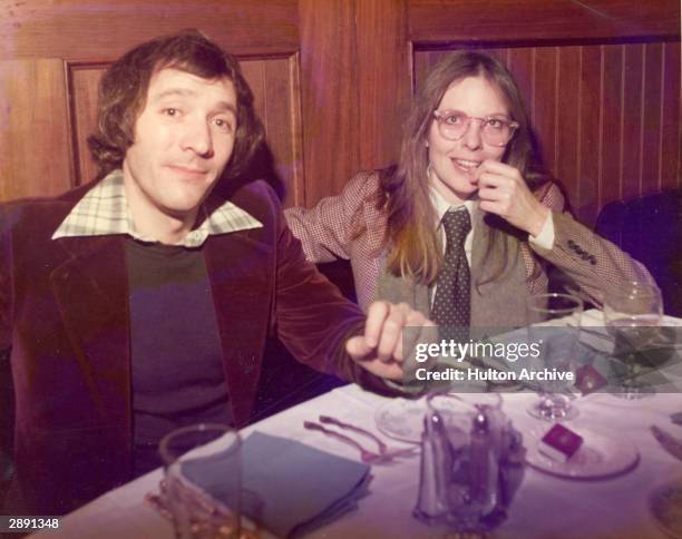 American actor and director Diane Keaton and an unidentified man sit at a table in a restaurant, circa 1980. Keaton is wearing a hound's tooth...