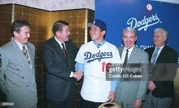 LOS ANGELES DODGERS'' PRESIDENT PETER O''MALLEY CONGRATULATES HIDEO NOMO OF JAPAN AFTER THE DODGERS SIGNED THE RIGHT HANDED PITCHER TO A MINOR LEAGUE...