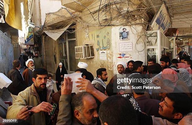 Faithful Iraqi Shia Muslims line up for Islamic advice from Grand Ayatollah Ali Sistani, Iraq's preeminent Shiite Muslim cleric, near the alleyway...