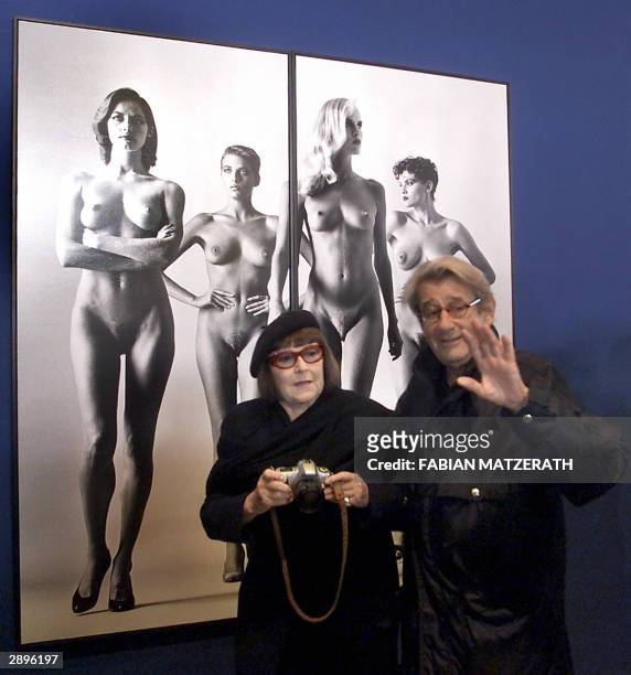 Picture taken 30 October 2000 in Berlin shows German photographer Helmut Newton and his wife Jude posing in front of one of his pictures dated 1981....