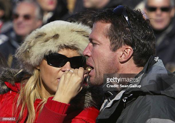 Former German football international Lothar Matthaeus is fed chocolate by his wife Mariana while watching the men's downhill at the Hahnenkamm Ski...