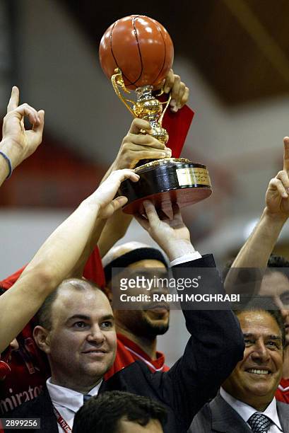Toni Madison and coach Fouad Abu Shakra and president of Lebanon's Champville club Henri Shalhoub raise the trophy of the Dubai International...