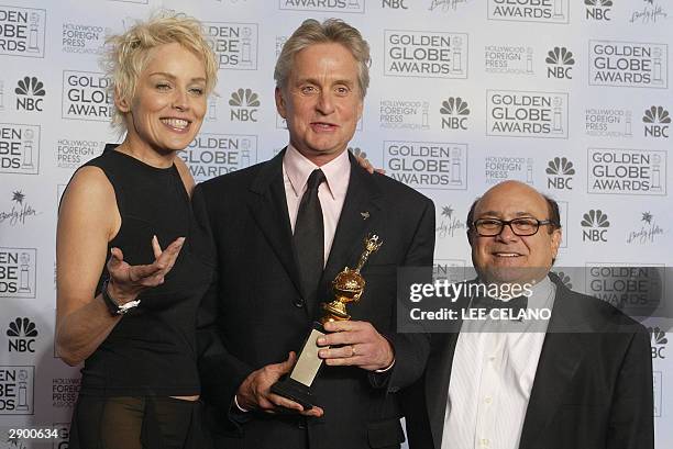 Actor Michael Douglas holds his Cecille B. DeMille award with presenters Sharon Stone and Danny Devito at the 61st Golden Globe awards in Beverly...