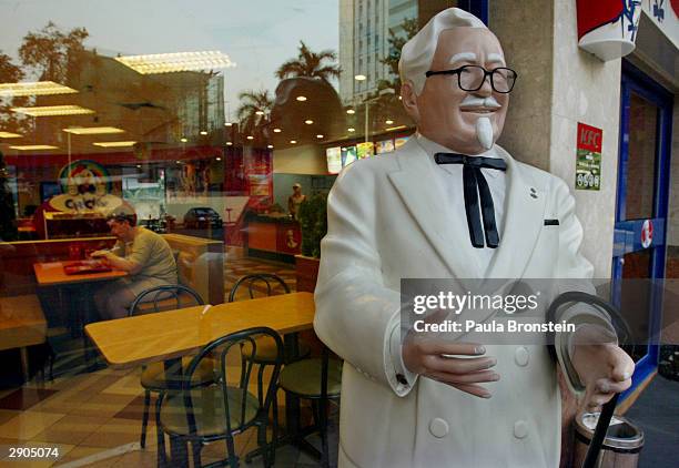 Statue of Colonel Harland Sanders, founder of Kentucky Fried Chicken stands on the street one of the fast food restaurants in Bangkok, Thailand...