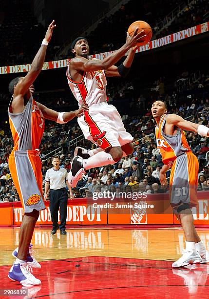 Jason Terry of the Atlanta Hawks shoots through Joe Johnson and Shawn Marion of the Phoenix Suns January 27, 2004 at Philips Arena in Atlanta,...