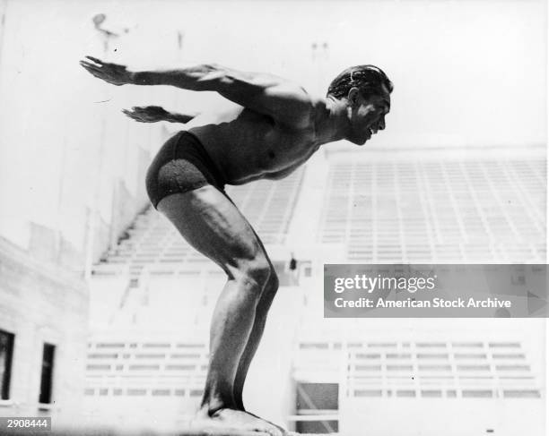 Side view of American swimmer and surfing pioneer Duke Kahanamoku preparing to dive in his fourth Olympic meet, circa 1920. He won gold medals in the...