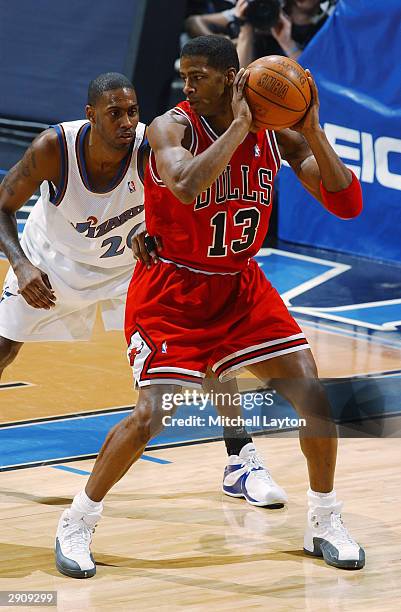 Kendall Gill of the Chicago Bulls looks to play the ball against Larry Hughes of the Washington Wizards during the game at MCI Center on January 19,...