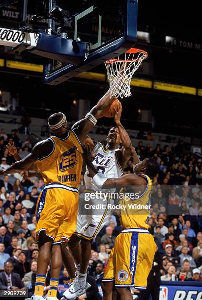 Raja Bell of the Utah Jazz takes the ball up against Erick Dampier and Mickael Pietrus of the Golden State Warriors during the NBA game at The Arena...