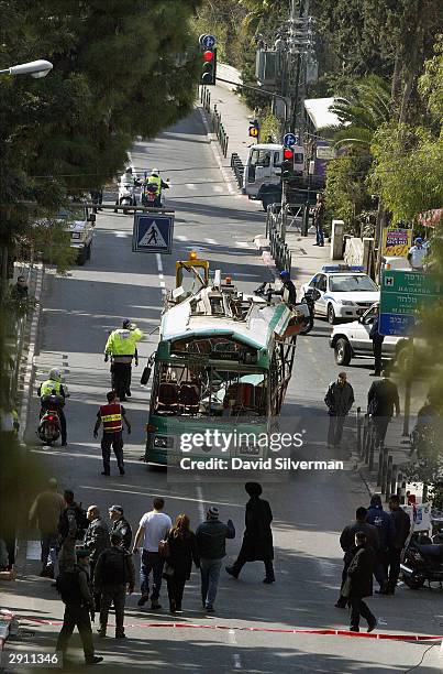 The shattered Israeli passenger bus is towed away under police escort from the scene of a suicide bomb attack January 29, 2004 in Jerusalem, Israel....