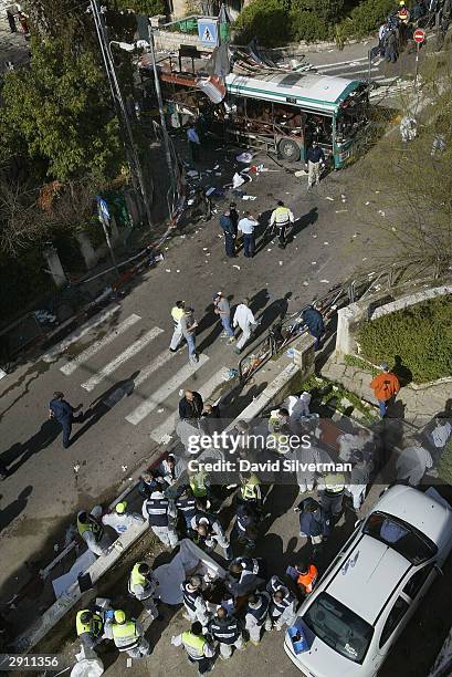 Israeli rescue workers tend to victims' bodies at the scene of a suicide bomb attack on a passenger bus January 29, 2004 in Jerusalem. The attack,...