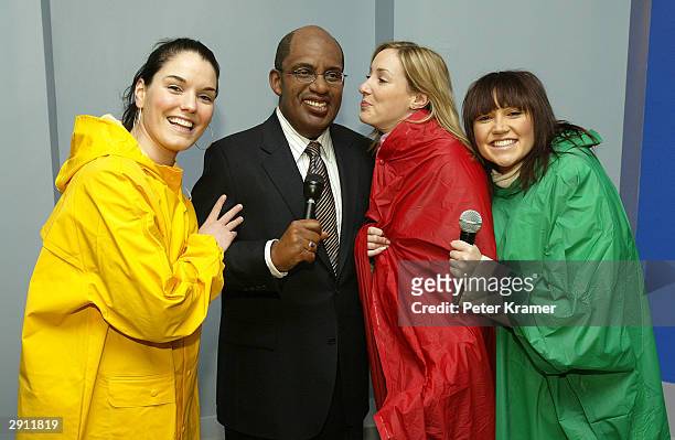Guest dressed as weather forecasters pose with the "Do The Weather With Al" experience wax figure at Madame Tussauds New York January 29, 2004 in New...