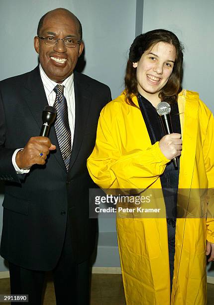 Guest dressed as a weather forecaster poses with the "Do The Weather With Al" experience wax figure at Madame Tussauds New York January 29, 2004 in...