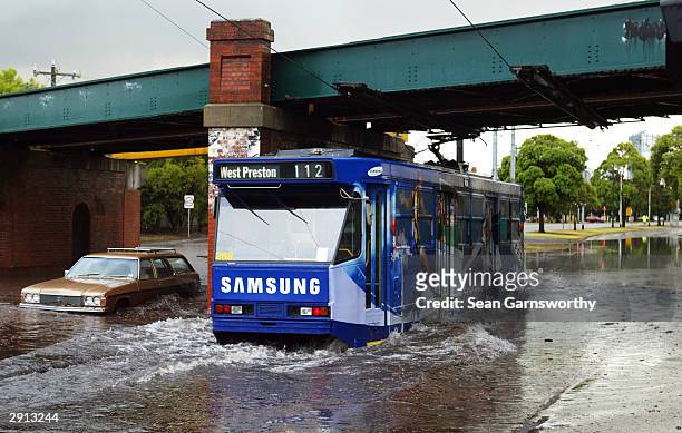 File photo shows a tram making its way through floodwaters in Melbourne's Albert Park after flash floods hit the city's inner suburbs January 30,...