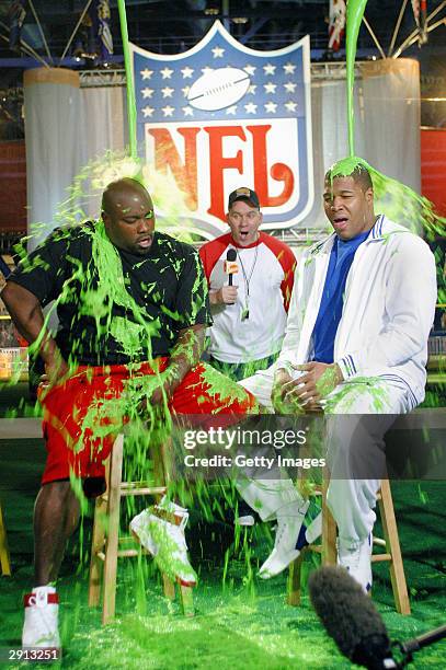 Mike O'Malley of CBS' "Yes, Dear" looks on as Warren Sapp of the Tampa Bay Buccaneers and Michael Strahan of the NY Giants get slimed during the...