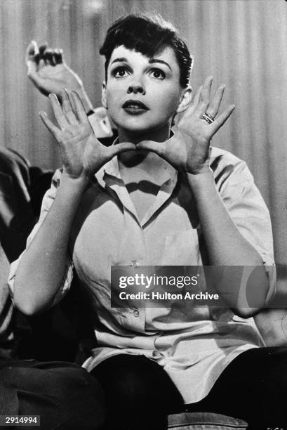 American actor and singer Judy Garland holds her hands up near her face, circa 1950s.