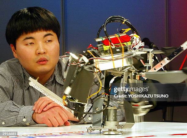 Amateur robot engineer Hisamitsu Miyata checks his hand-made two-legged robot "Quick Turn 2" before a fight during the fifth radio-controlled robot...