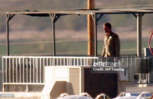 One of two inmates holding a hostage at the State Prison Complex-Lewis walks on the observation deck of a guard tower, wearing a guard's shirt...