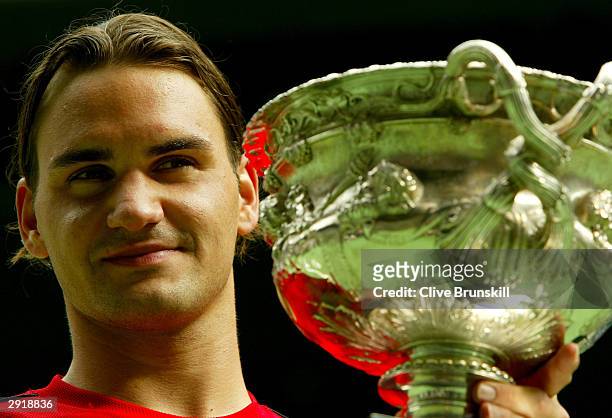 Roger Federer of Switzerland holds up the Australian Open Trophy after victory against Marat Safin of Russia during the Mens Singles Final during day...