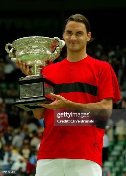 Roger Federer of Switzerland holds up the Australian Open Trophy after victory against Marat Safin of Russia during the Mens Singles Final during day...