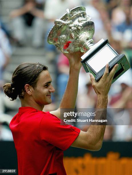 Roger Federer of Switzerland holds up the Australian Open Trophy after his victory against Marat Safin of Russia during the Mens Singles Final during...