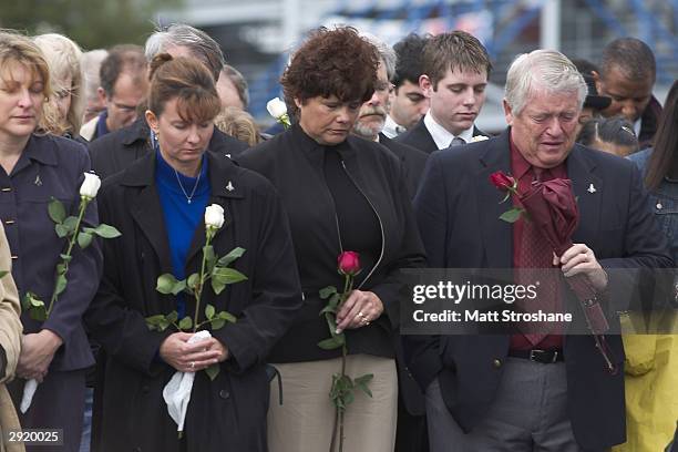 Visitors wait to leave flowers at the base of the Space Mirror Memorial after a memorial ceremony for fallen astronauts at the Kennedy Space Center...