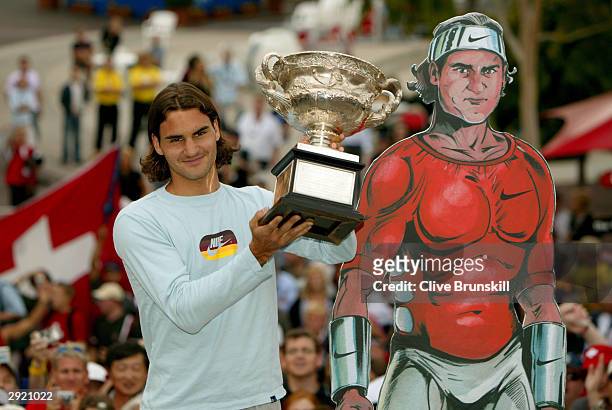 Roger Federer of Switzerland greets fans and holds up the trophy after winning the Australian Open Grand Slam against Marat Safin of Russia during...