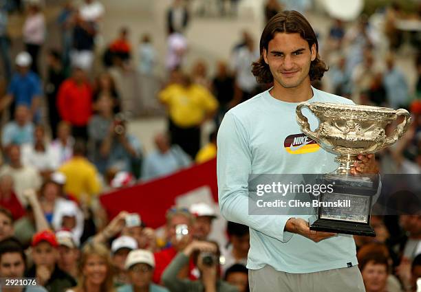 Roger Federer of Switzerland greets fans as he holds the trophy for winning the Australian Open Grand Slam against Marat Safin of Russia during day...