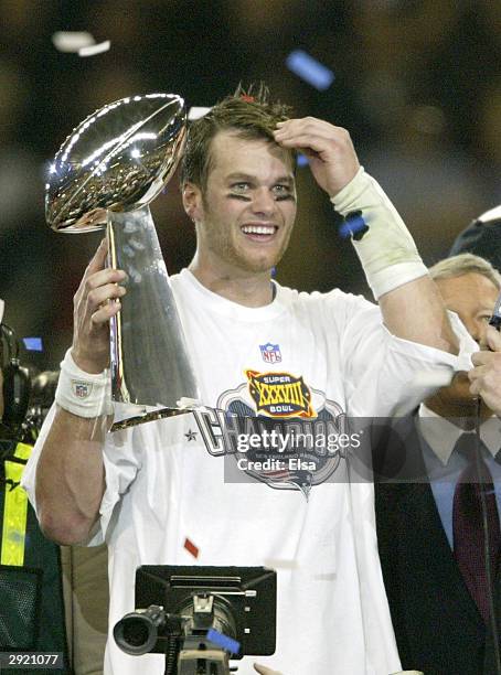 Tom Brady of the New England Patriots raises the Lombardi trophy as he is interviewed by television commentator Jim Nance after defeating the...