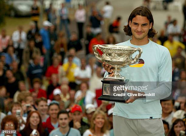 Roger Federer of Switzerland greets fans as he holds the trophy for winning the Australian Open Grand Slam against Marat Safin of Russia during day...