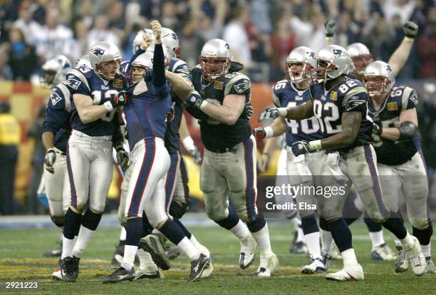 New England Patriots players jump on teammate Adam Vinatieri after he kicked the winning field goal in the fourth quarter against the Carolina...