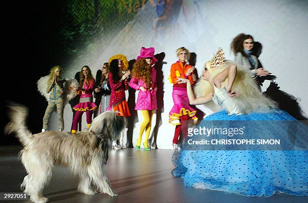 Spanish designer Nekane poses with her dog Friki as she displays an outfit she designed at the Pasarela Gaudi fashion show 04 February 2004 in...