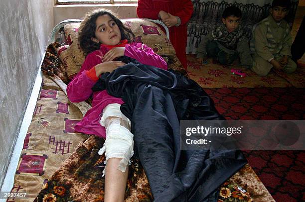 Iraqi child Basma, suffering from shrapnel wounds to her leg, rests on a bed 04 February 2004 in the Iraqi northern city of Kirkuk. The US army...